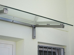 Glasvordach aus quadratischen Edelstahlrohren